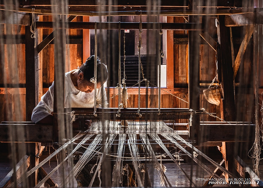 织布工坊,门里是挤匝密匝一架挨一架的织布机,但并不是家家机器前都有
