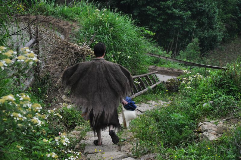 天下起了蒙蒙细雨,穿着蓑衣的庄稼人.